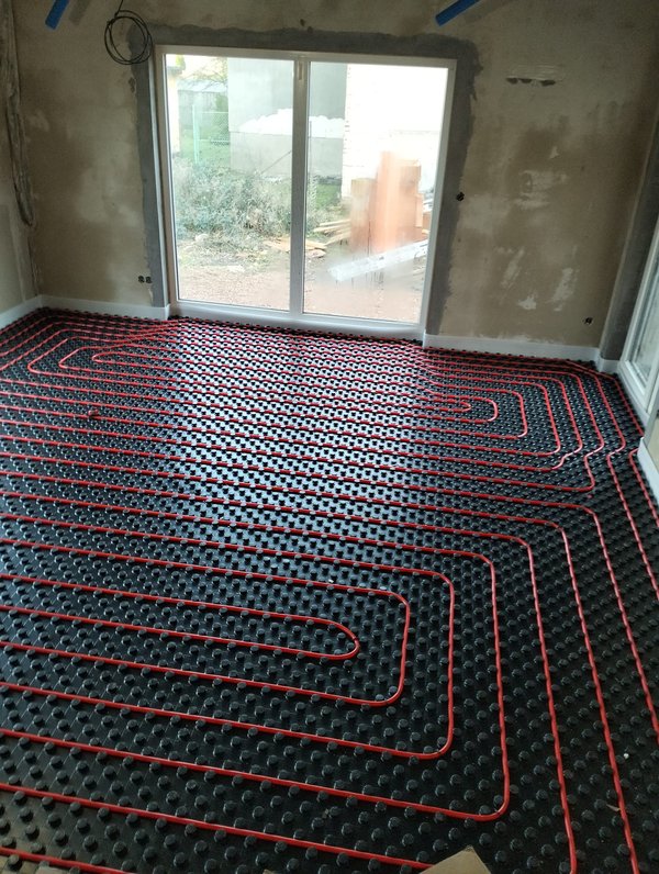 Podlahové topení – červené trubky na termoizolaci — realizace Kolín